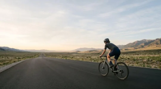 Amateur cyclist riding at steady low intensity on quiet road, capturing the mental discipline of zone 2 training