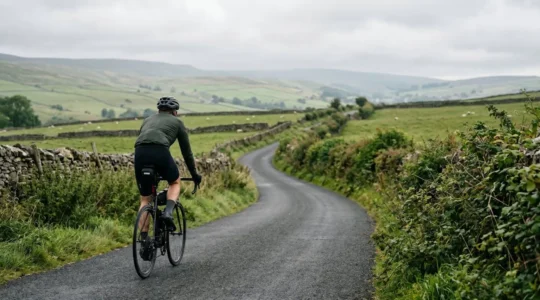 Cyclist navigating a peaceful rural country lane using GPS device in British countryside