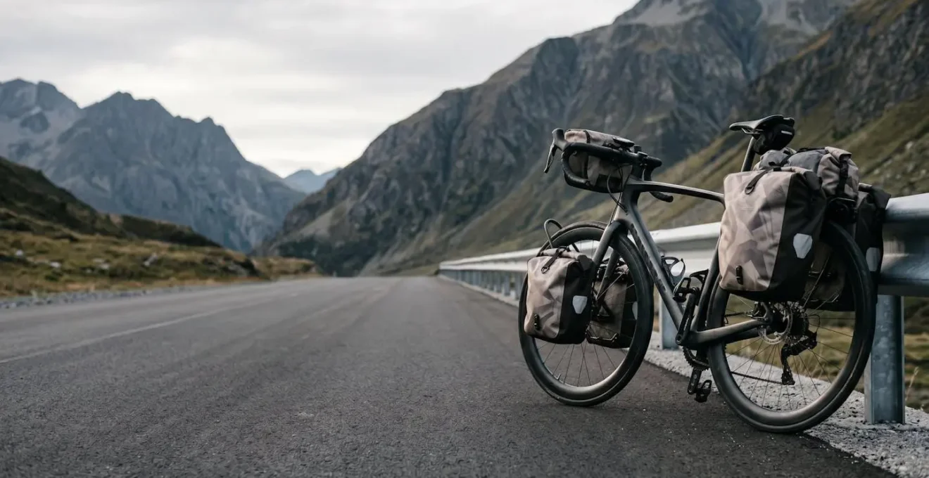 Professional cyclist on aggressive race geometry bicycle struggling with balance under heavy touring panniers load